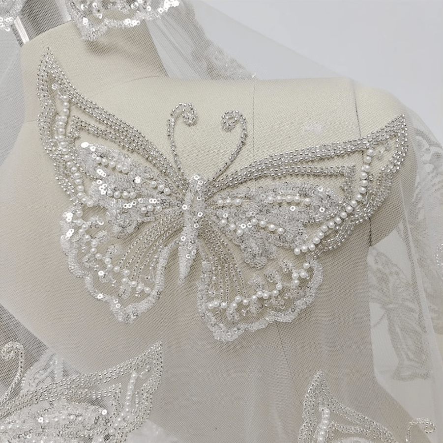 Fluturi accesorizate
cu perle, margele si paiete pe argintiu,baza tull off white.